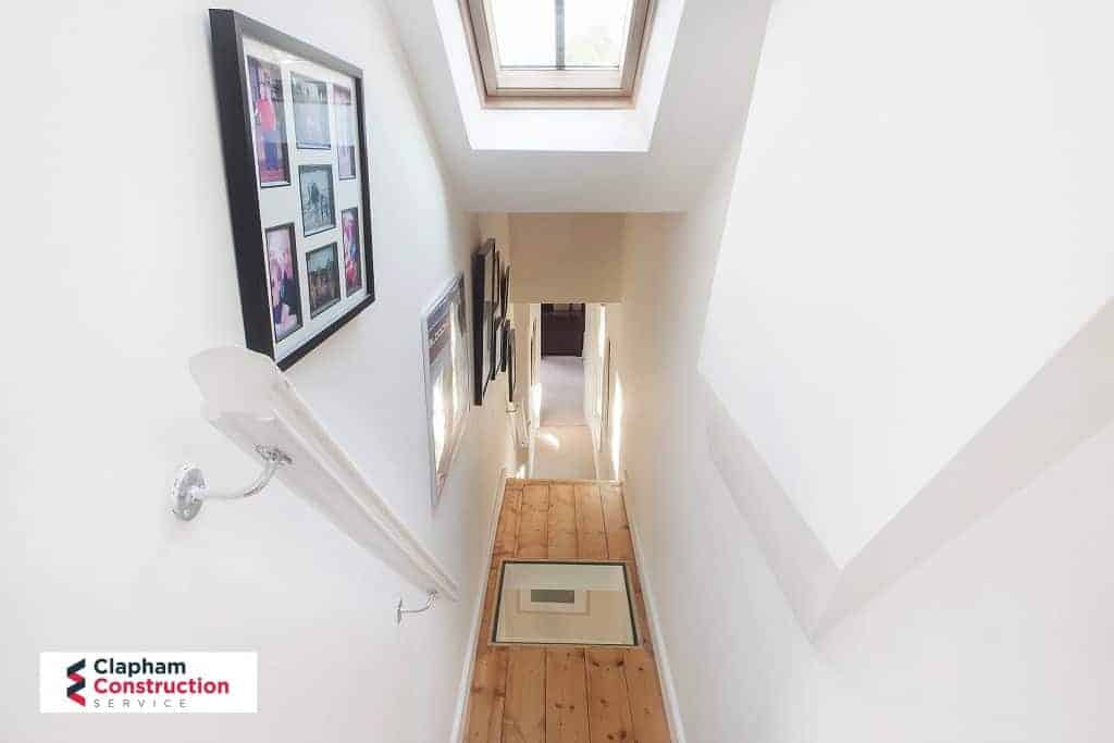 ferry-road-loft-conversion-landing finished loft conversion with stairs and glass hallway floor