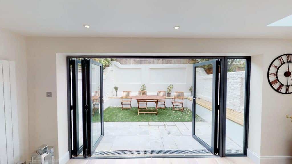 completed home extension bi-folding doors white brick wall garden furniture