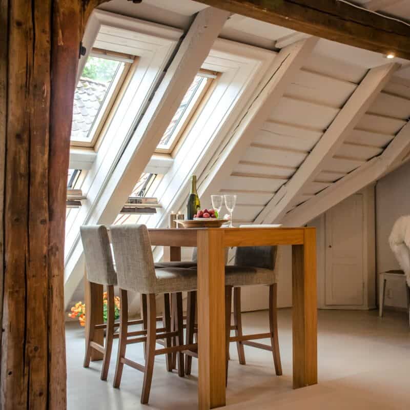 brown wooden dining table with two gray seats near opened window